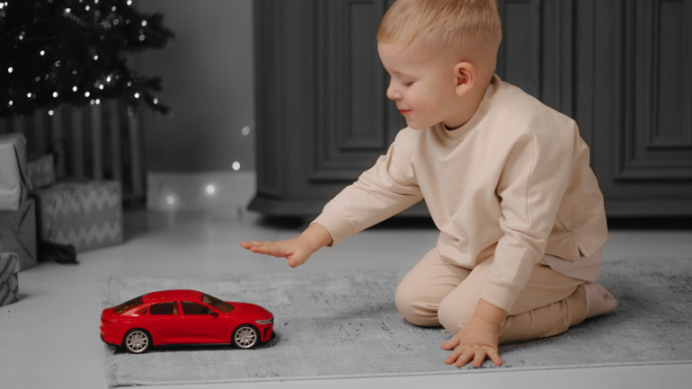 Enfant qui joue avec une voiture miniature